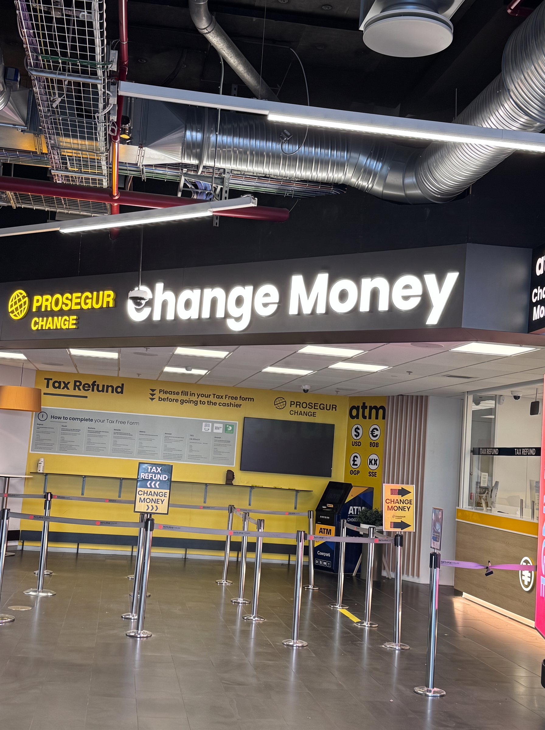 Change Money currency exchange and tax refund counter at Keflavík Airport, with cash machines beside it